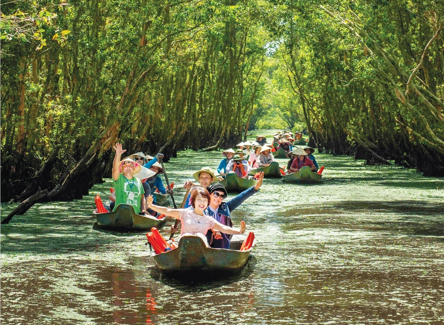 Chiếc xuồng ba lá lướt nhẹ theo từng nhịp dầm khua nước giữa hai hàng tràm rợp bóng xanh mát tạo cảm giác thư thái cho khách du lịch khi trải nghiệm (Du lịch xuồng chèo ở khu du lịch sinh thái Gáo Giồng (huyện Tháp Mười, tỉnh Đồng Tháp) 