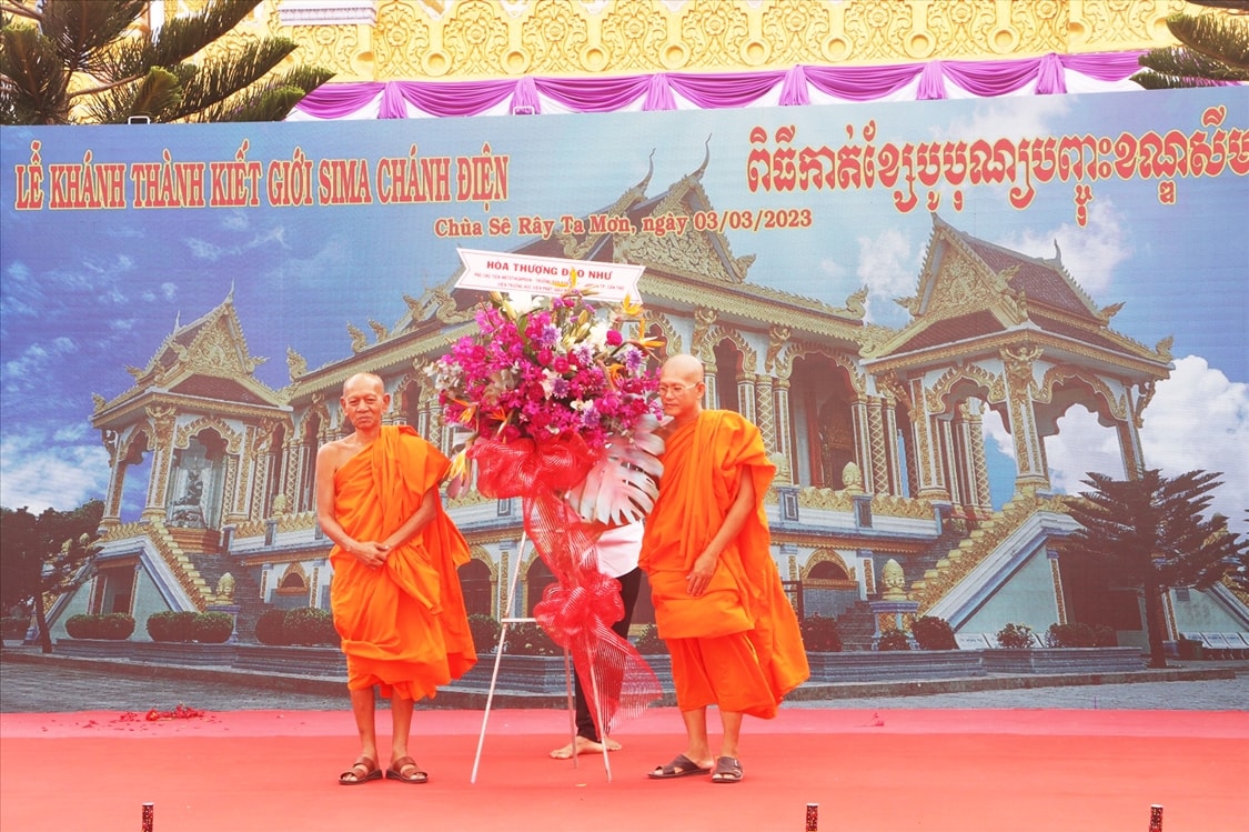 Hòa thượng Đào Như (bên trái) - Phó Chủ tịch Hội đồng trị sự GHPG Việt Nam trao hoa chúc mừng đến trụ trì chùa Sê Rây Tà Mơn