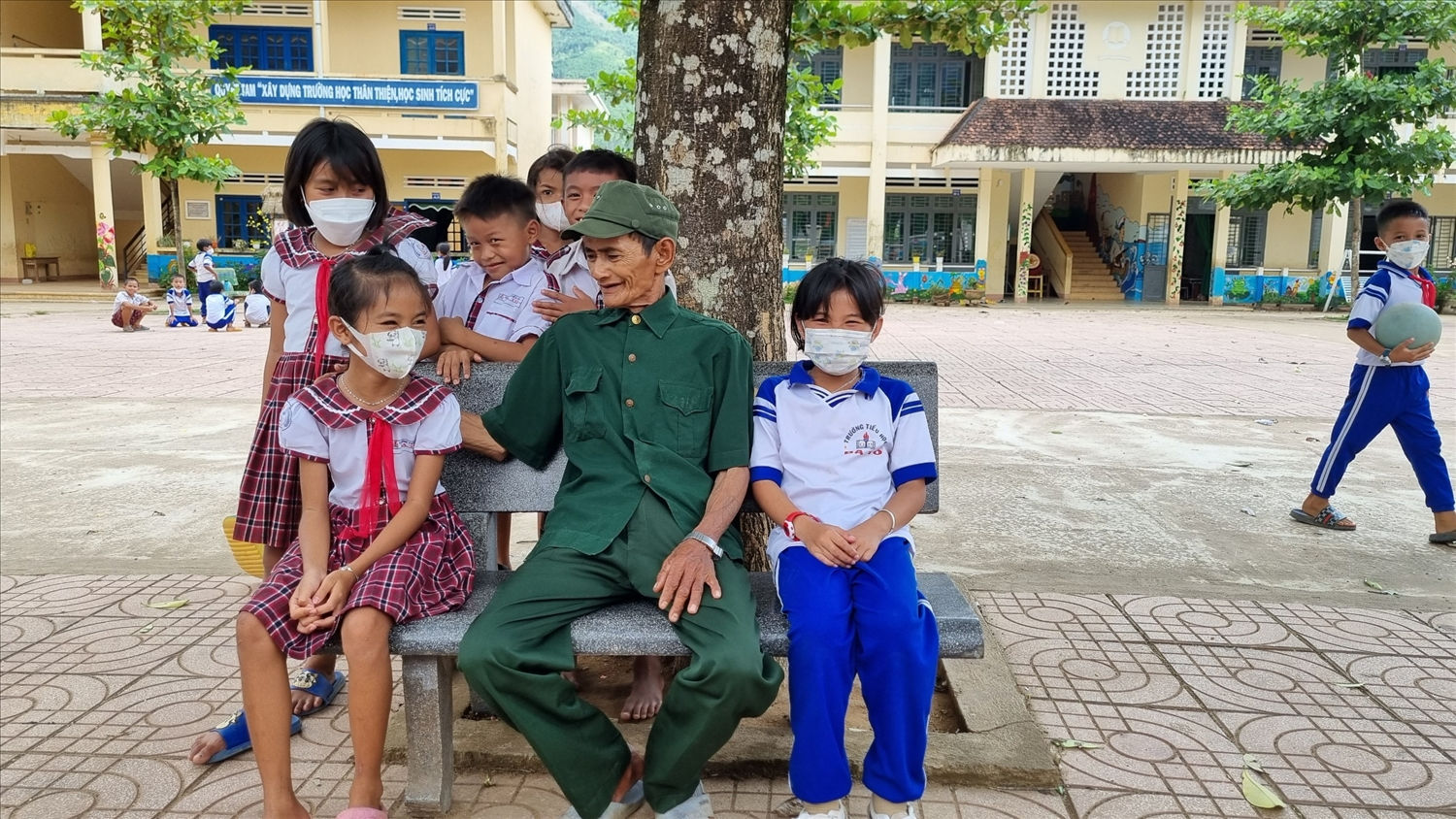 Ông Phạm Thanh Mong vui vẻ trò chuyện cùng các cháu học sinh Trường Tiểu học xã Ba Tô, huyện Ba Tơ (Quảng Ngãi)