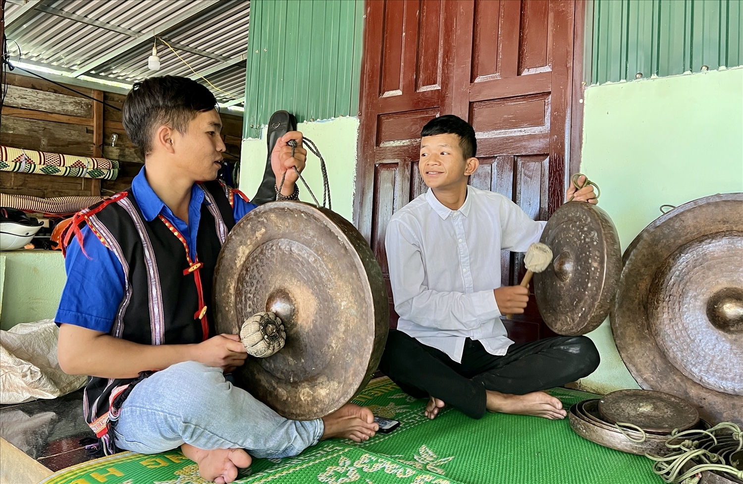 Anh Siu Thanh (bên trái) hướng dẫn thanh niên trong thôn cách đánh cồng chiêng 