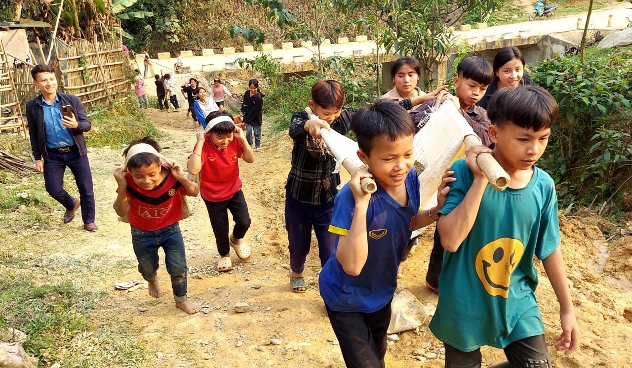 Học sinh Trường PTDTBT Tiểu học và THCS vận chuyển giúp mẹ con anh Ân làm nhà mới