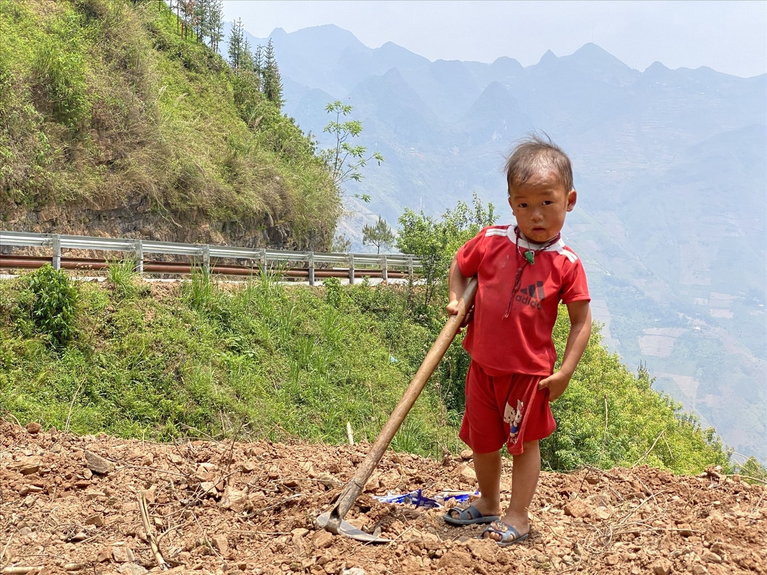 Em bé cuốc đất trồng ngô bên hẻm Tu Sản hùng vĩ