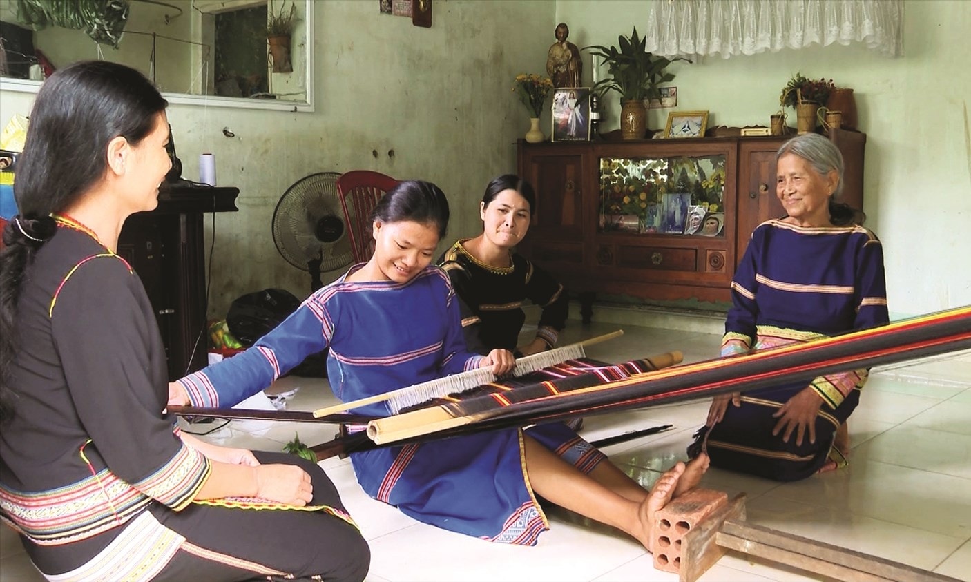 Bà Y Chrưt chỉ cho con, cháu cách dệt truyền thống.
