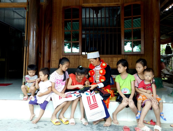 Chị Lý Thị Mụi, dân tộc Dao ở thôn Bản Tụm, xã Tân Mỹ đang dạy, truyền nghề cho các cháu gái trong họ hàng