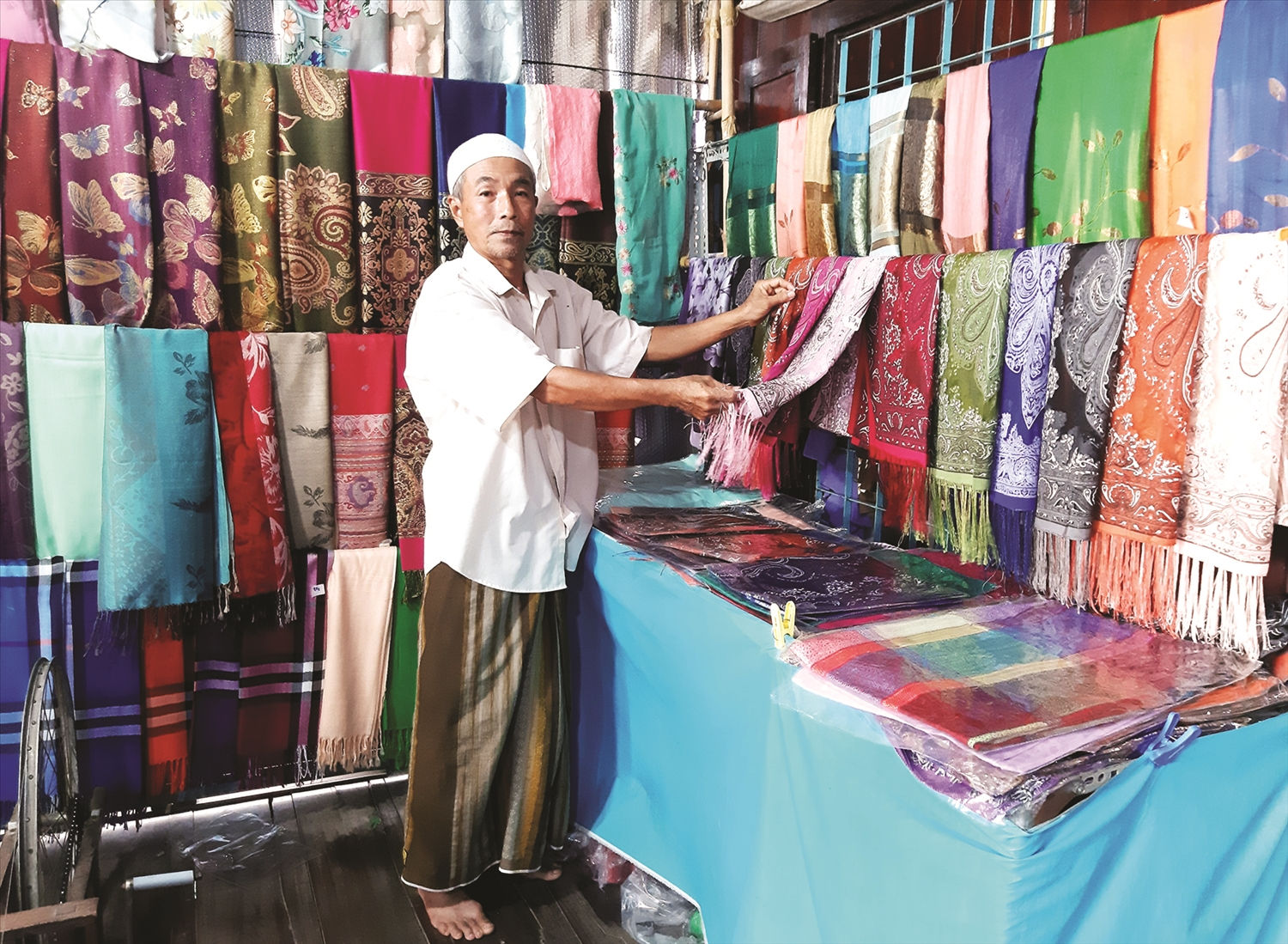 Ông Mohamad bày trí không gian thổ cẩm của đồng bào Chăm.