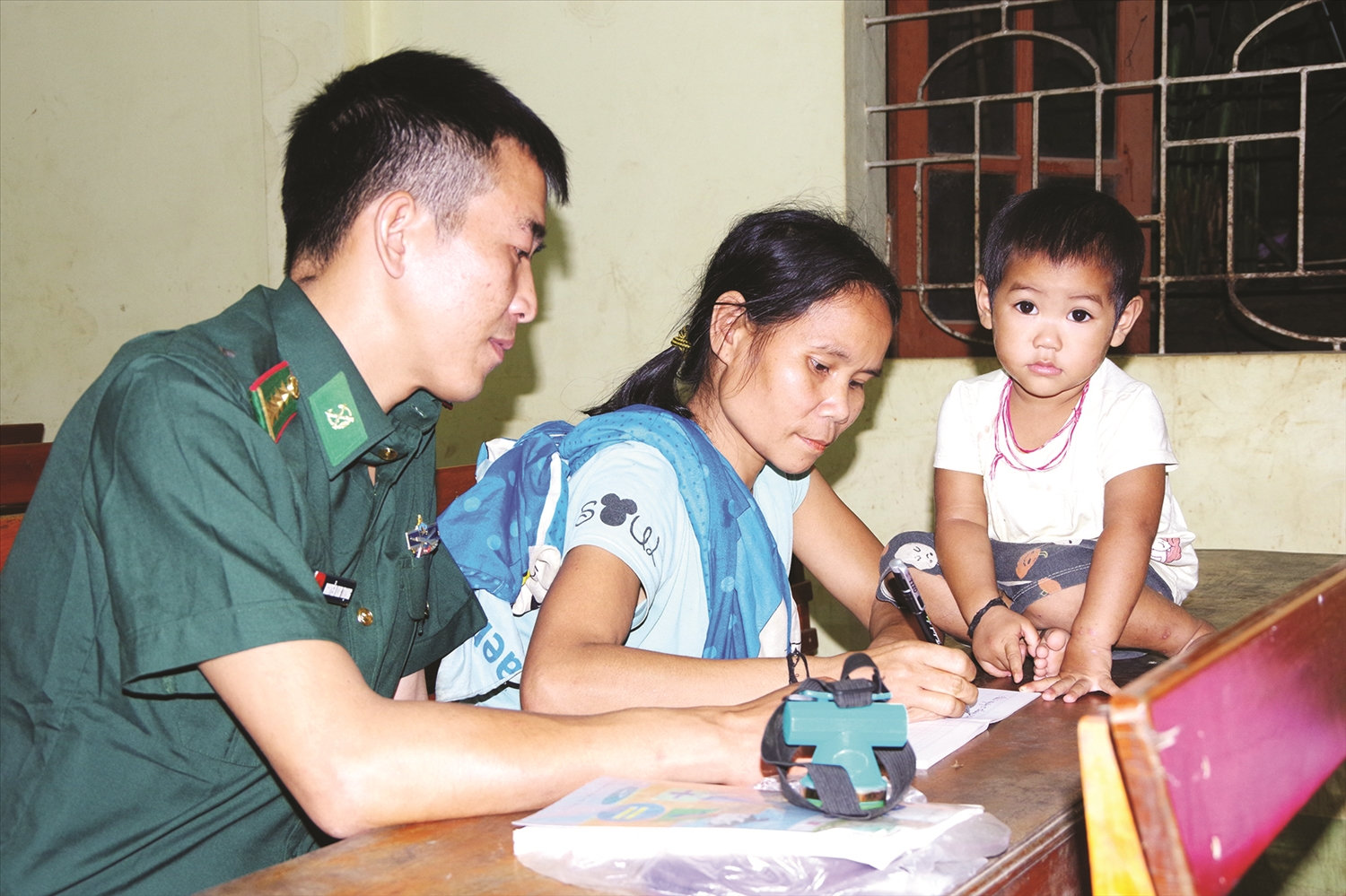 Đại uý Nguyễn Kim Trọng hướng dẫn các chị học viên học đánh vần.