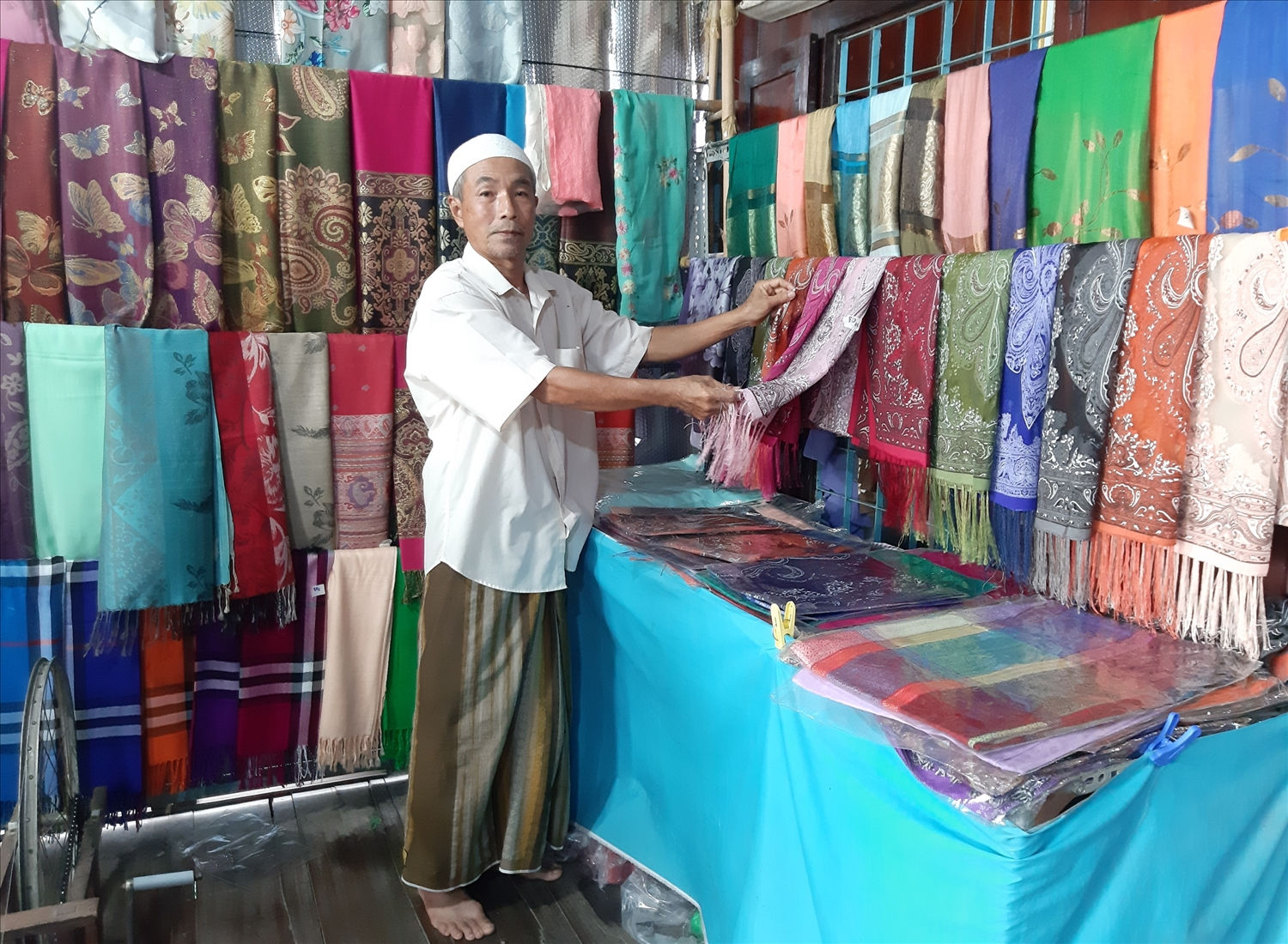 Ông Mohamad-thành viên HTX dệt thổ cẩm Châu Phong (xã Châu Phong, TX. Tân Châu, An Giang) giới thiệu với du khách những sản phẩm thổ cẩm của HTX.