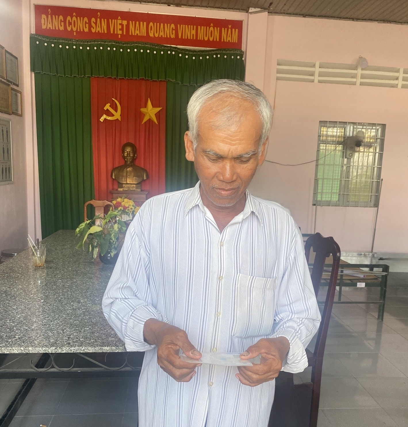 Ông Kim Thông Người có uy tín ấp Bến Chùa, xã Phước Hưng, huyện Trà Cú phấn khởi bên chiếc thẻ bảo hiểm