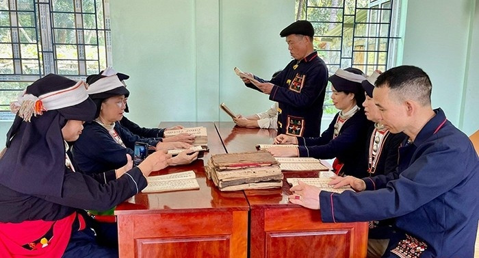 (Một buổi truyền dạy chữ Dao của ông Triệu Văn Nguyên, Người uy tín thôn Bình Sơn (người đứng) cho người dân trong xã