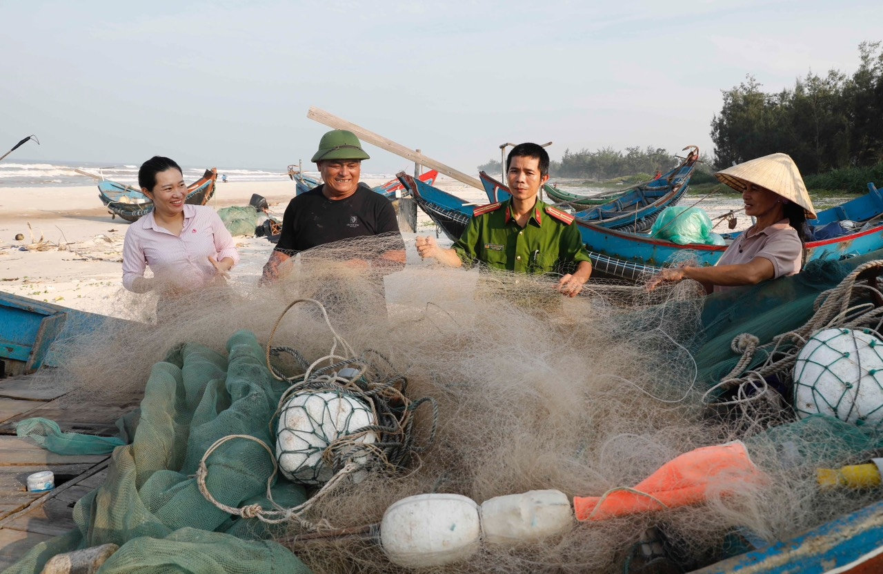 Vợ chồng ông Lê Văn Bình ở xã Ngư Thuỷ, huyện Lệ Thủy vui mừng khoe với cán bộ NHCSXH huyện và Công an xã khi nhận được 100 triệu đồng tiền vay về  mua ngay ngư lưới cụ, phục vụ đánh bắt hải sản