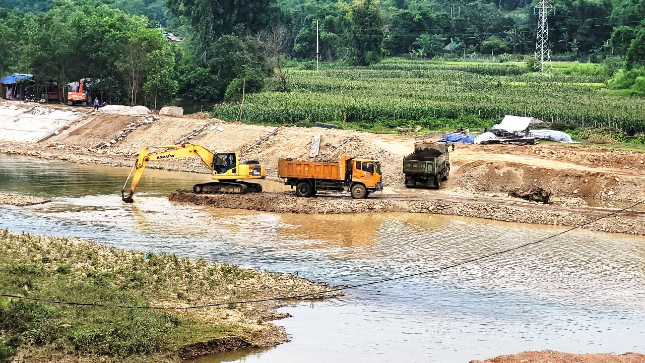 Nhà thầu thi công dùng máy xúc, ô tô khai thác cát sỏi dưới sông rồi đổ lên bờ làm vật liệu lu lèn xây dựng kè Nhà thầu thi công dùng máy xúc, ô tô khai thác cát sỏi dưới sông rồi đổ lên bờ làm vật liệu lu lèn xây dựng kè
