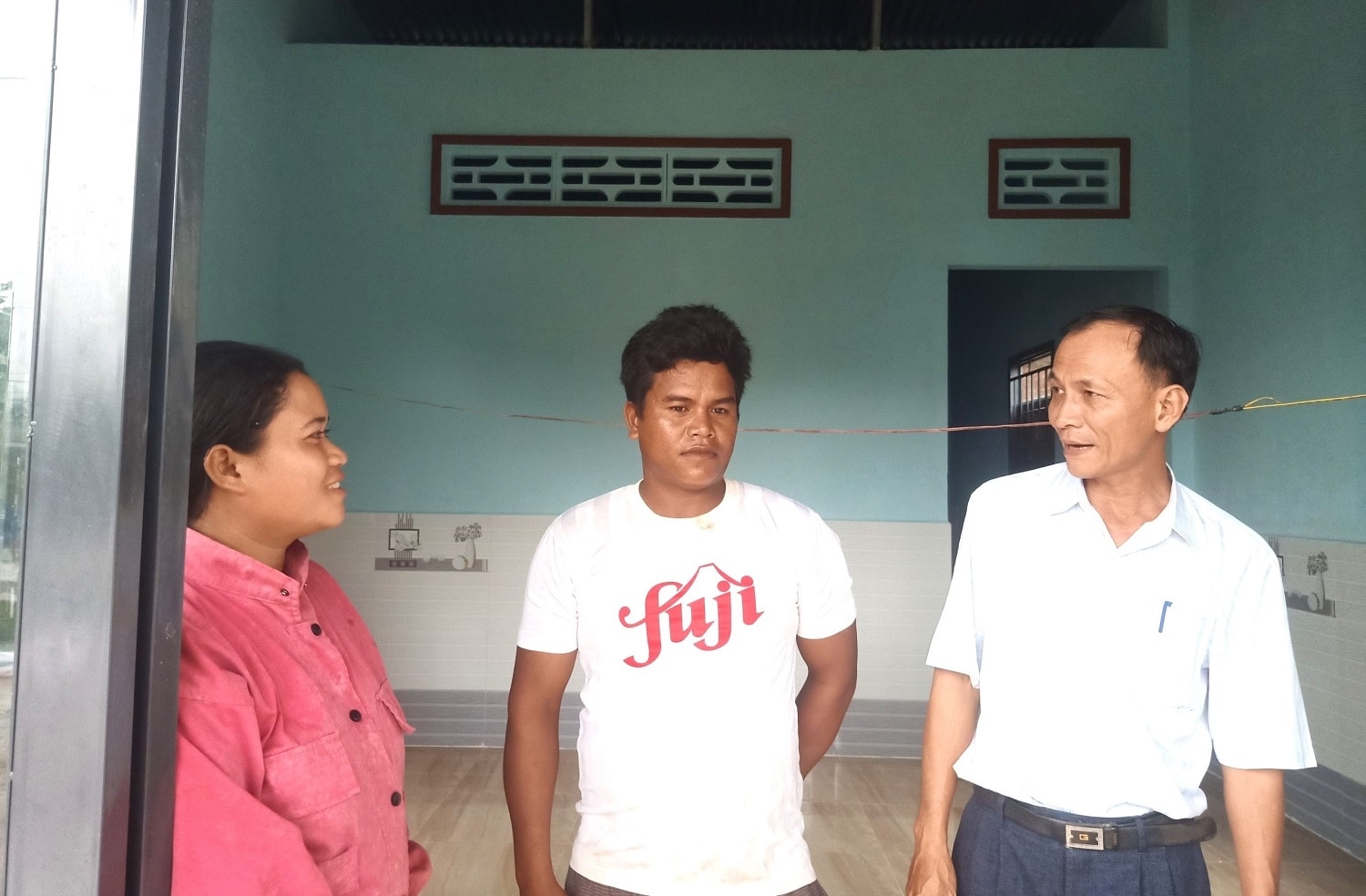 Ông Đặng Công Khanh, Chủ tịch UBND xã La Ngâu (bên phải), thăm hỏi trò chuyện cùng anh B'rong Xuyên  (đứng giữa) tại ngôi nhà mà anh vừa được hỗ trợ xây mới theo chương trình MTQG 1719