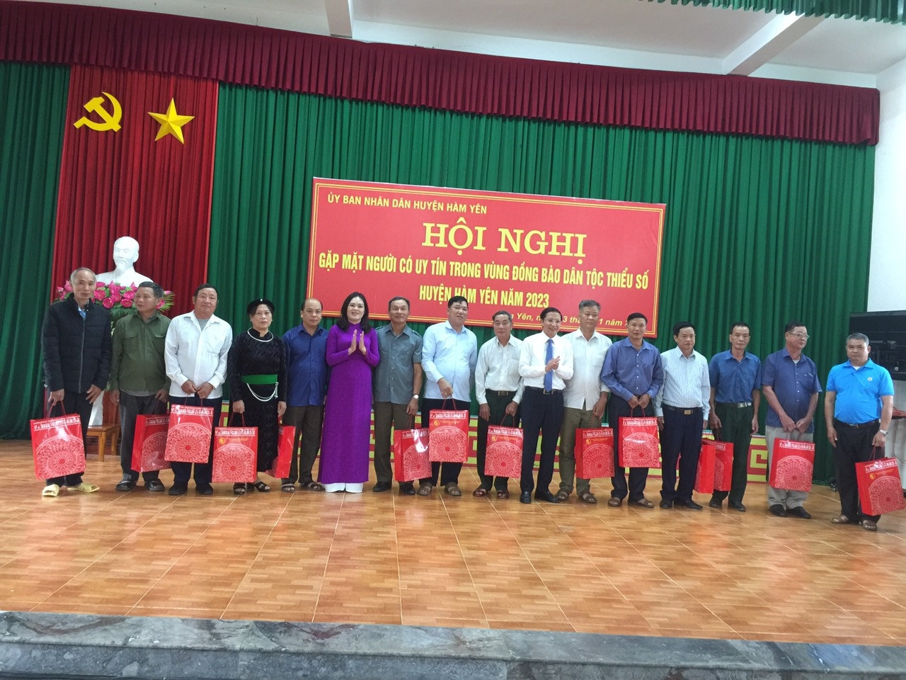 Ông Mai Hồng Hà (thứ bảy, từ phải sang) và bà Hoàng Thị Thắm, Phó trưởng Ban Dân tộc tỉnh Tuyên Quang (thứ sáu, từ trái sang) trao quà cho Người có uy tín tham dự Hội nghị.