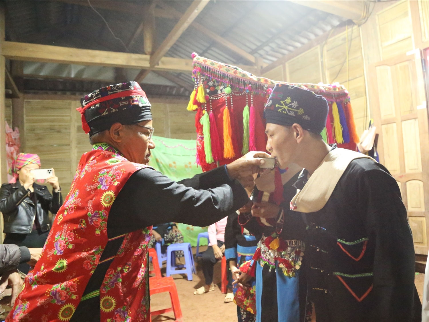 Thầy cúng làm lễ giao bôi gắn kết cho chú rể và cô dâu