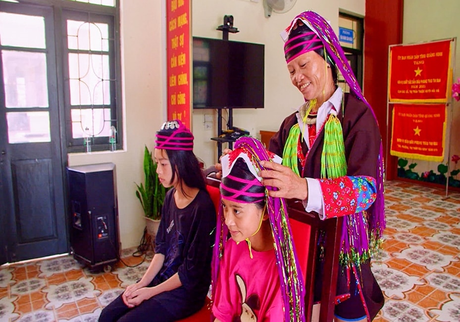 Bà Chìu Thị Lan hướng dẫn cách vấn tóc cho học sinh Trường PTDT nội trú THCS Quảng Sơn