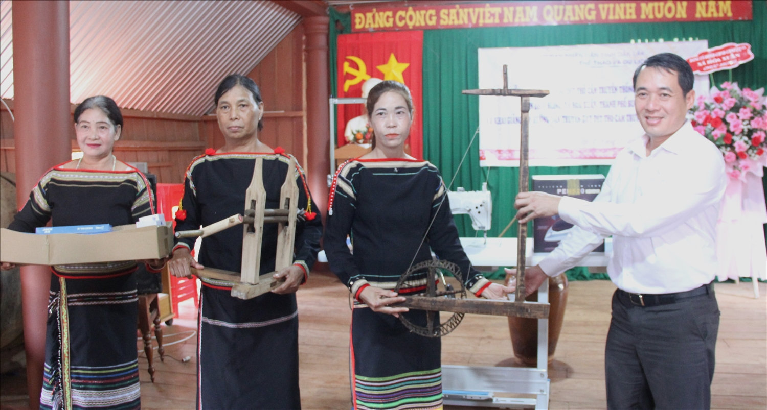 Phó giám đốc Sở Văn hóa, Thể thao và Du lịch tỉnh Đắk Lắk trao máy móc, dụng cụ dệt thổ cẩm, may trang phục truyền thống cho Câu lạc bộ dệt thổ cẩm của người Ê Đê buôn Drai H’ling