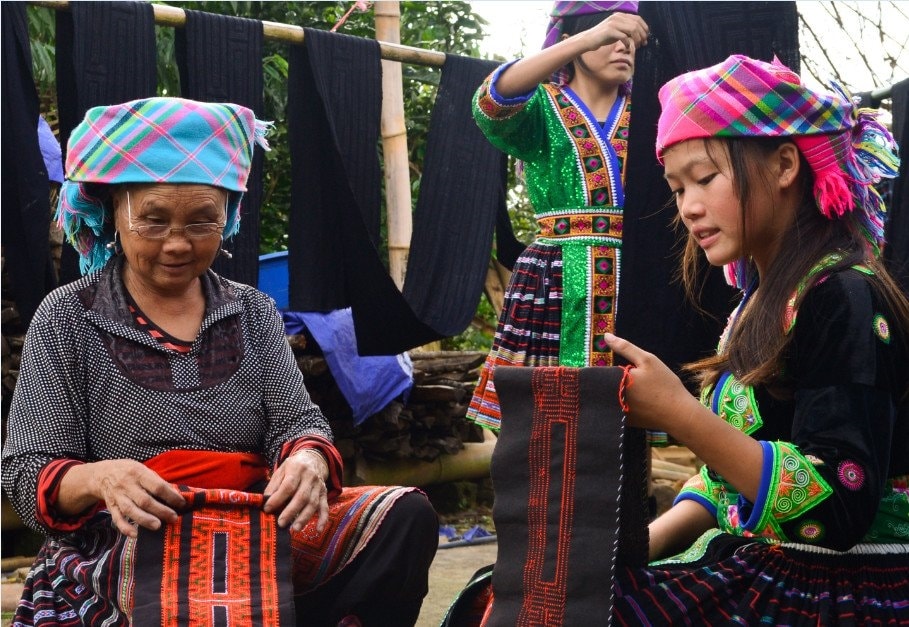 Bà Dủ dạy cháu thêu hoa văn trên vải để may váy áo. Bà Dủ dạy cháu thêu hoa văn trên vải để may váy áo.