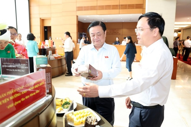 Bí thư Huyện uỷ Mường Ảng Nguyễn Tiến Đạt (bên phải) giới thiệu với Bộ trưởng Bộ Nông nghiệp và Phát triển Nông thôn Lê Minh Hoan về sản phẩm đặc sản cà phê Mường Ảng