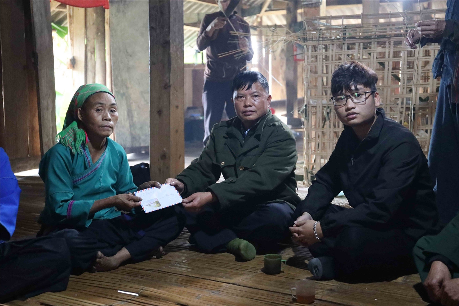 Ông Lù Kim Triệu, Phó trưởng Phòng Dân tộc huyện Hoàng Su Phì cùng Phóng viên Báo Dân tộc và Phát triển treo tiền hỗ trợ cho gia đình nạn nhân Sin Sào Bình