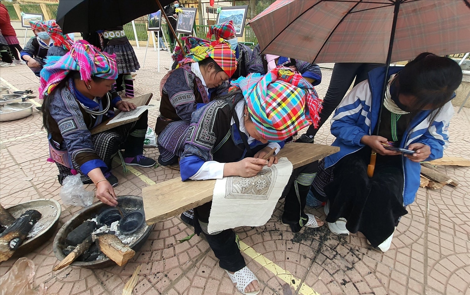 Phụ nữ Mông thường ngồi bên bếp lửa giữ sáp ong được đủ nhiệt độ để vẽ Phụ nữ Mông thường ngồi bên bếp lửa giữ sáp ong được đủ nhiệt độ để vẽ