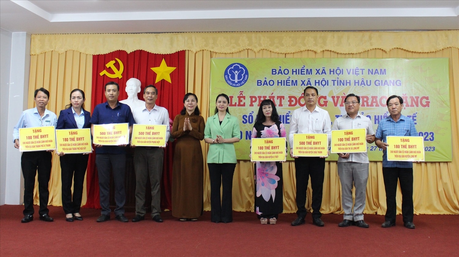 Bà Võ Thị Mỹ Trang, Phó Chủ tịch HĐND tỉnh Hậu Giang và bà Nguyễn Thị Thanh Xuân, Giám đốc BHXH tỉnh trao bảng tượng trưng tặng thẻ BHYT đến đại diện các huyện, thị xã, thành phố thuộc tỉnh Hậu Giang 