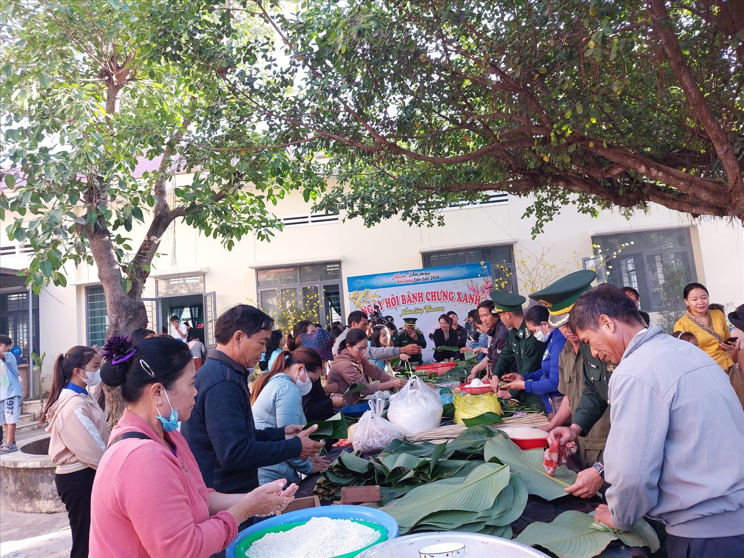 Cán bộ, chiến sĩ và đại biểu tham dự chương trình cùng Nhân dân gói bánh chưng
