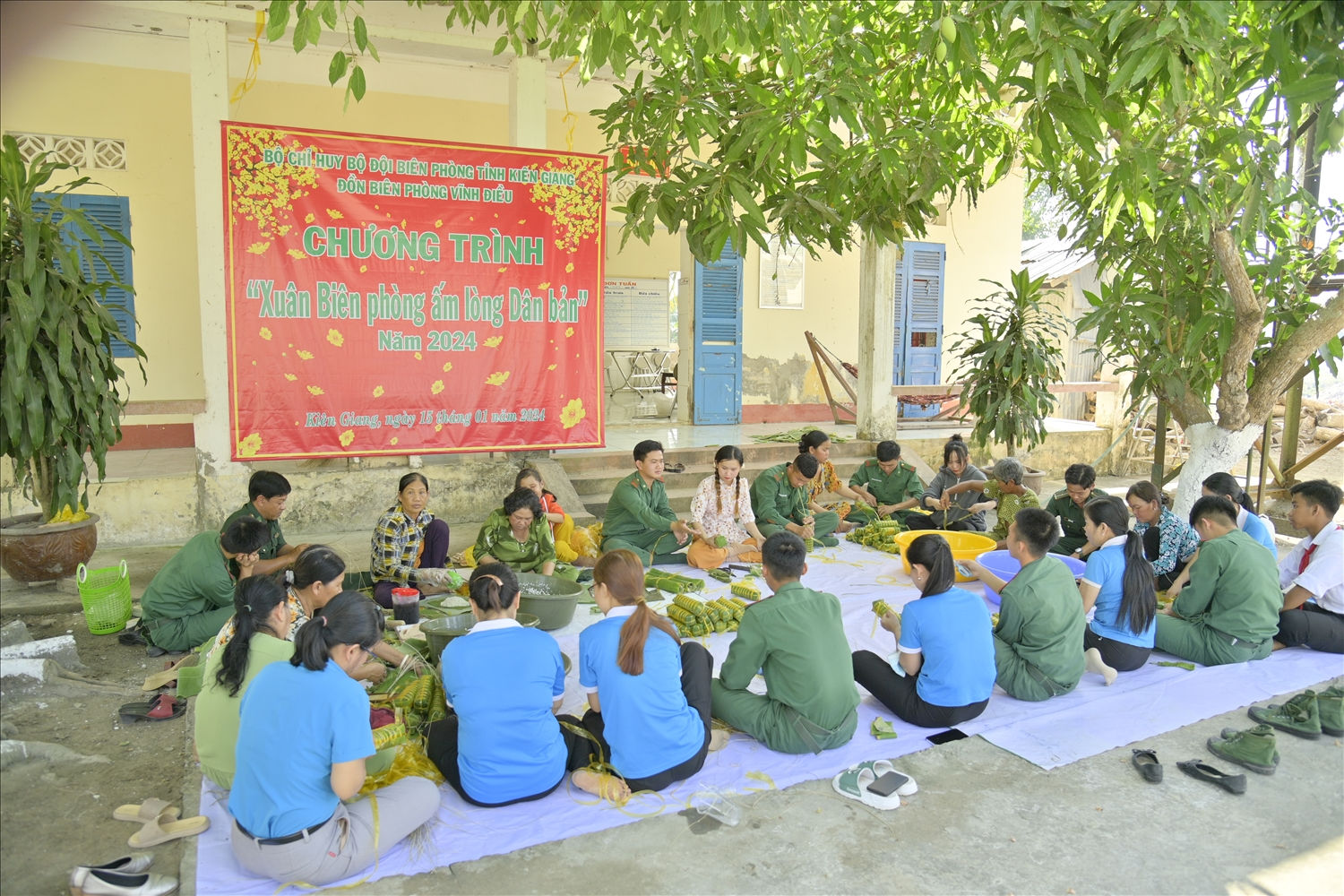 Cán bộ, chiến sĩ đồn Biên phòng Vĩnh Điều cùng tham gia gói bánh tét với người dân địa phương