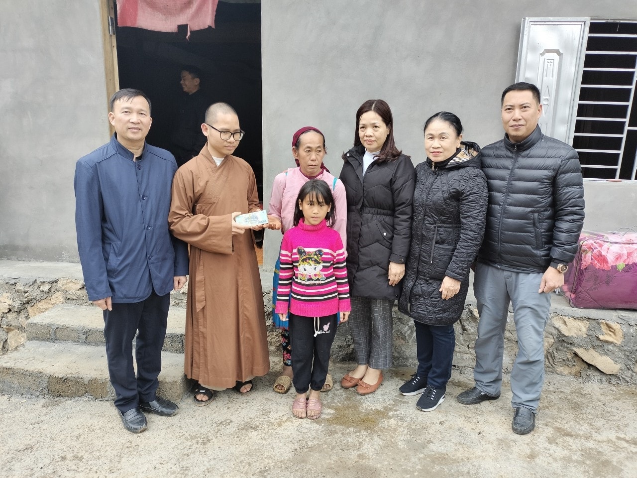 Đại diện các phật tử, Uỷ ban MTTQ tỉnh Hà Giang và chính quyền địa phương bàn giao nhà cho em Giàng Mí Nô và Giàng Thị Máy