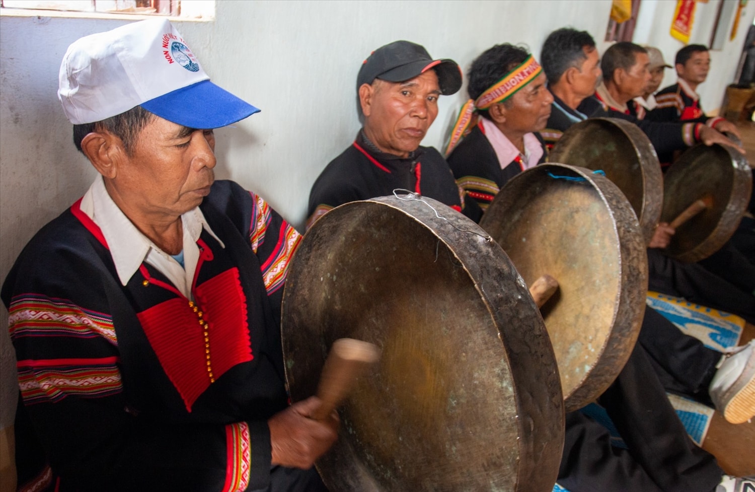 Trong nhà cộng đồng, các nghệ nhân đánh những bài chiêng truyền thống