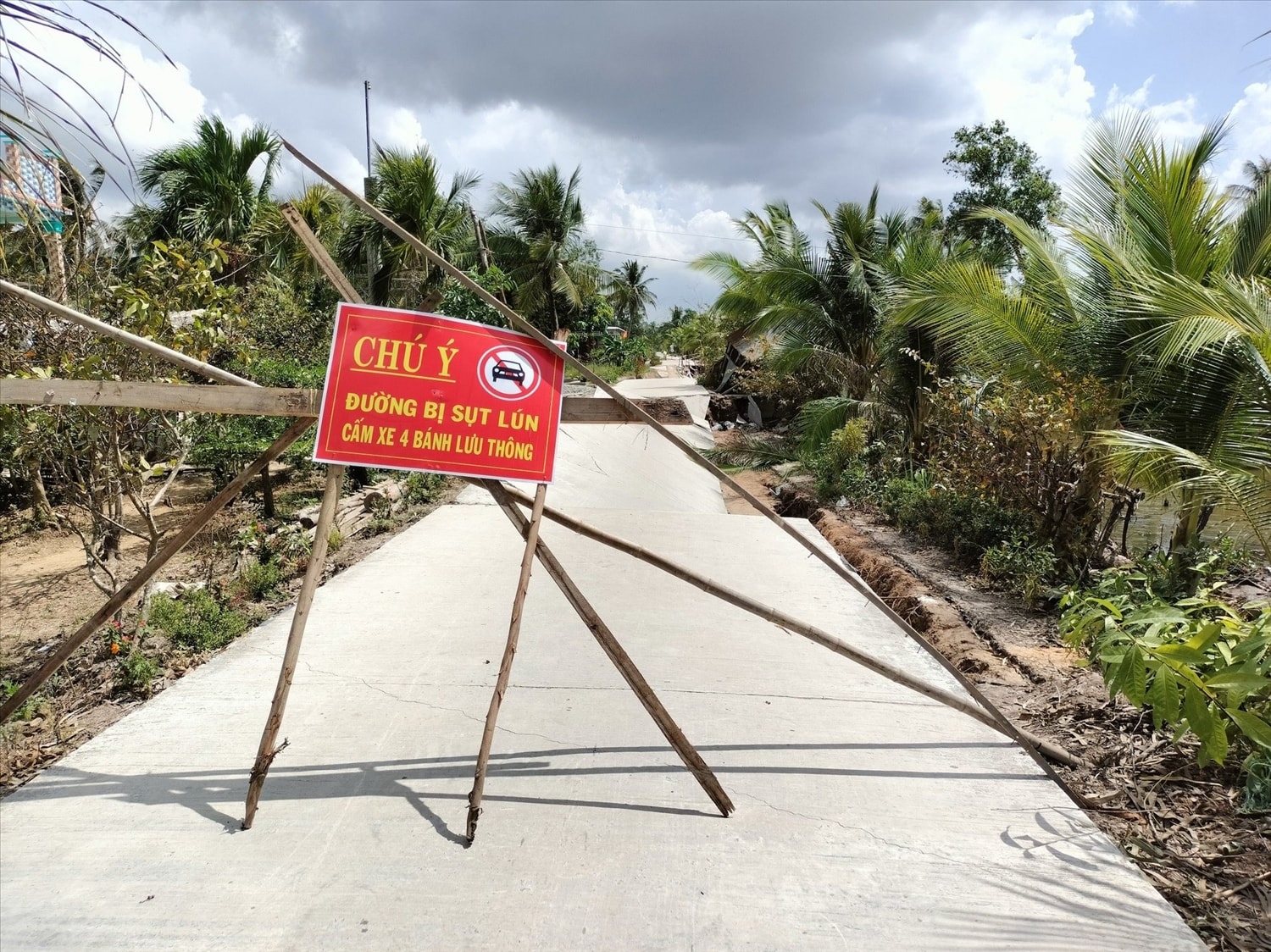 Cao độ đáy kênh sâu, độ chênh lệch độ cao giữa mặt đường và mực nước hiện tại rất lớn, làm mất phản áp gây sụt lún. Người dân giăng dây, làm rào chắn, biển cảnh báo hạn chế giao thông.