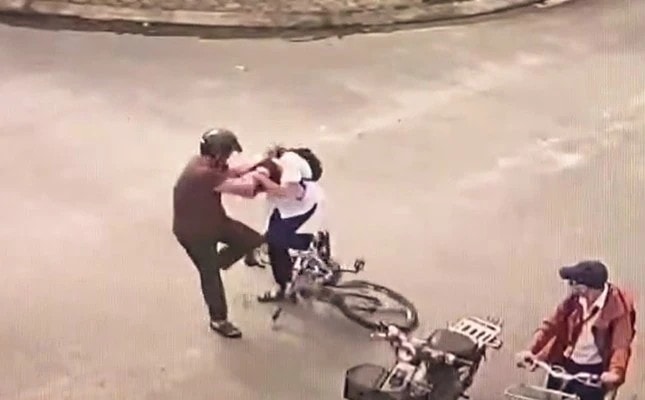 Camera ghi lại cảnh cháu K. bị ông P.T.M chặn đường rồi đánh tới tấp đến mức cháu phải nhập viện cấp cứu. Ảnh cắt từ clip. Camera ghi lại cảnh cháu K. bị ông P.T.M chặn đường rồi đánh tới tấp đến mức cháu phải nhập viện cấp cứu. Ảnh cắt từ clip.