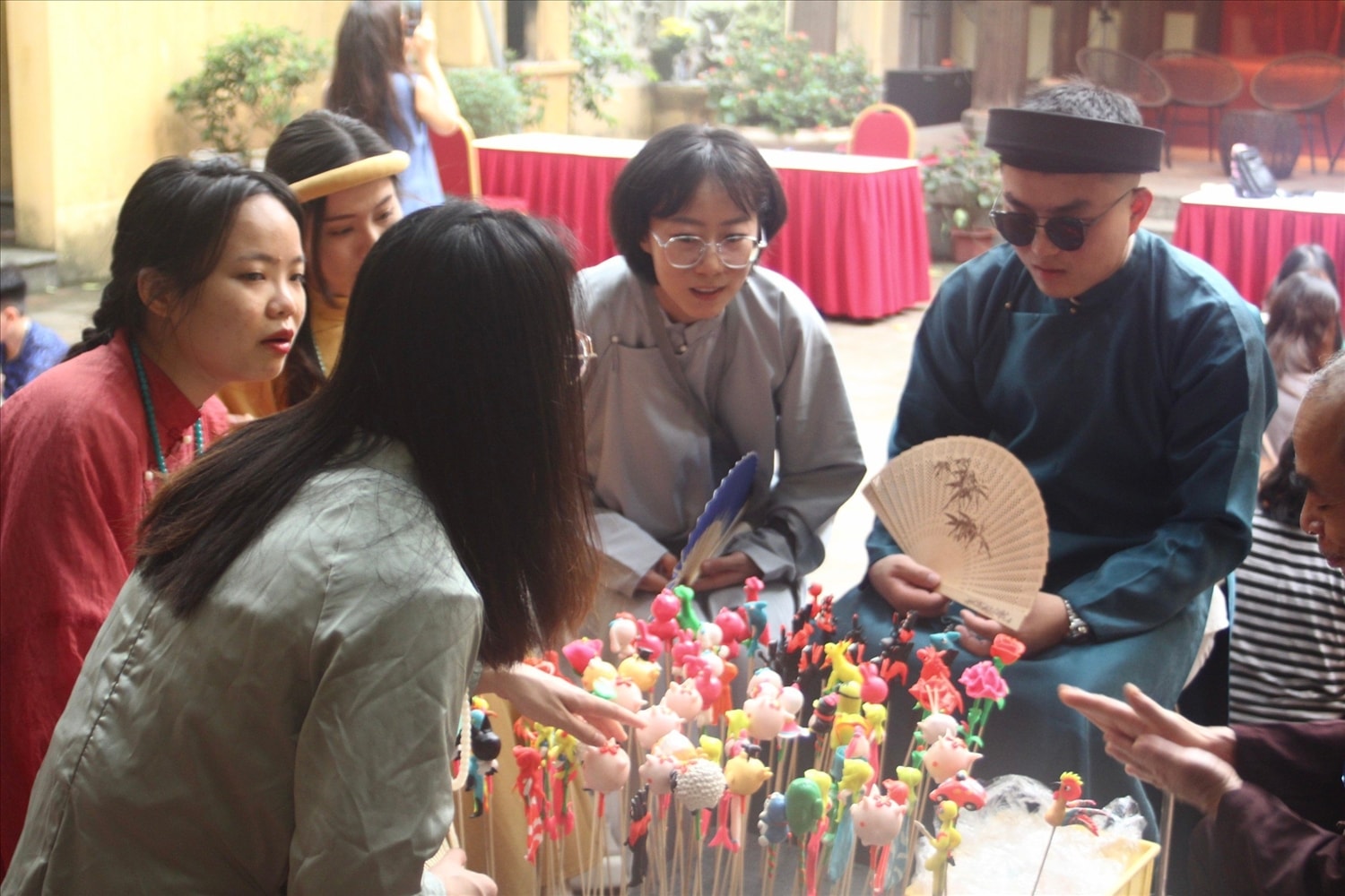 Khách tham quan mặc thử trang phục truyền thống và được các nghệ nhân hướng dẫn nặn tò he