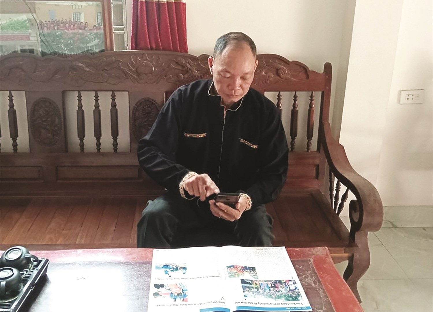 Nhờ được trang bị điện thoại thông minh, ông Bàn Hữu An đã có thể cài đặt  các ứng dụng, tiện ích cần thiết, kịp thời giải đáp những thắc mắc  của Nhân dân về chế độ chính sách