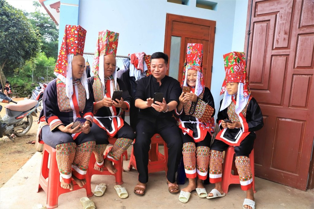 Cán bộ xã Đồng Tâm (Bình Liêu) hướng dẫn người dân sử dụng điện thoại thông minh để cài đặt các ứng dụng BHXH trên ứng dụng VNeID