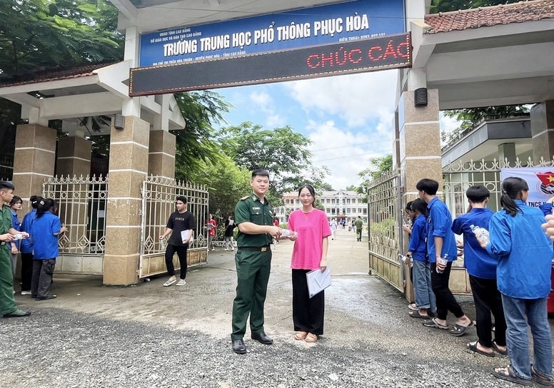 Cán bộ Đồn Biên phòng Cửa khẩu Quốc tế Tà Lùng tiếp nước cho sĩ tử tại điểm thi. (Ảnh: Minh Đức)