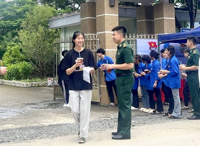Thí sinh vui vẻ nhận nước uống từ Cán bộ Đồn Biên phòng Cửa khẩu Quốc tế Tà Lùng. (Ảnh: Minh Đức)