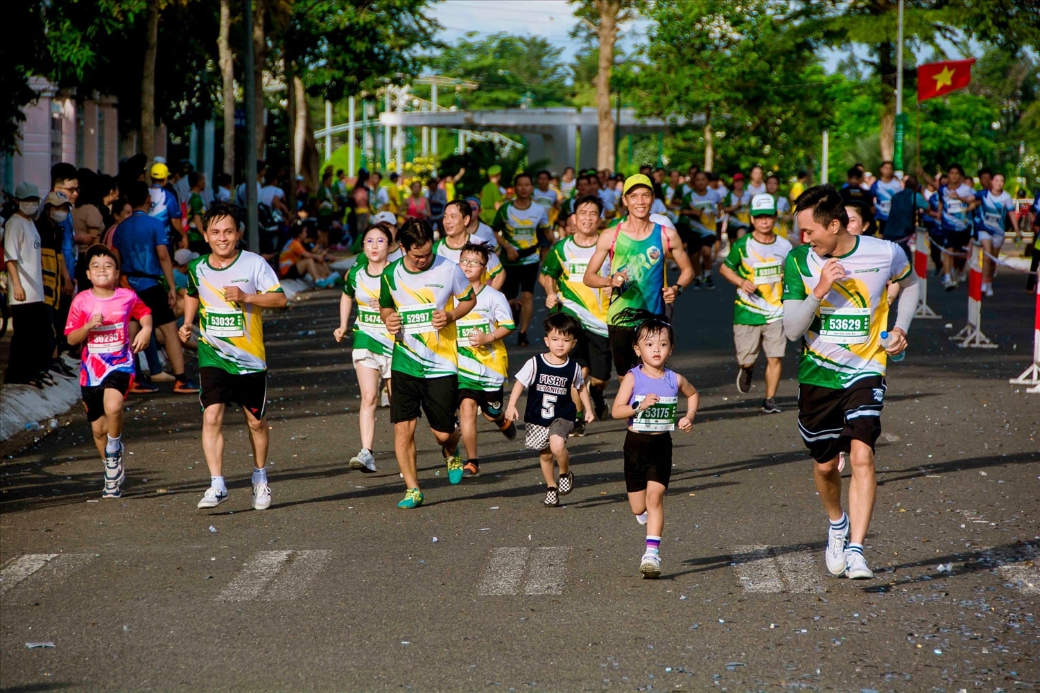 Các vận động  nhí với màu áo tím hồng nổi bật trên đường chạy cùng gia đình về đích cự ly 5km