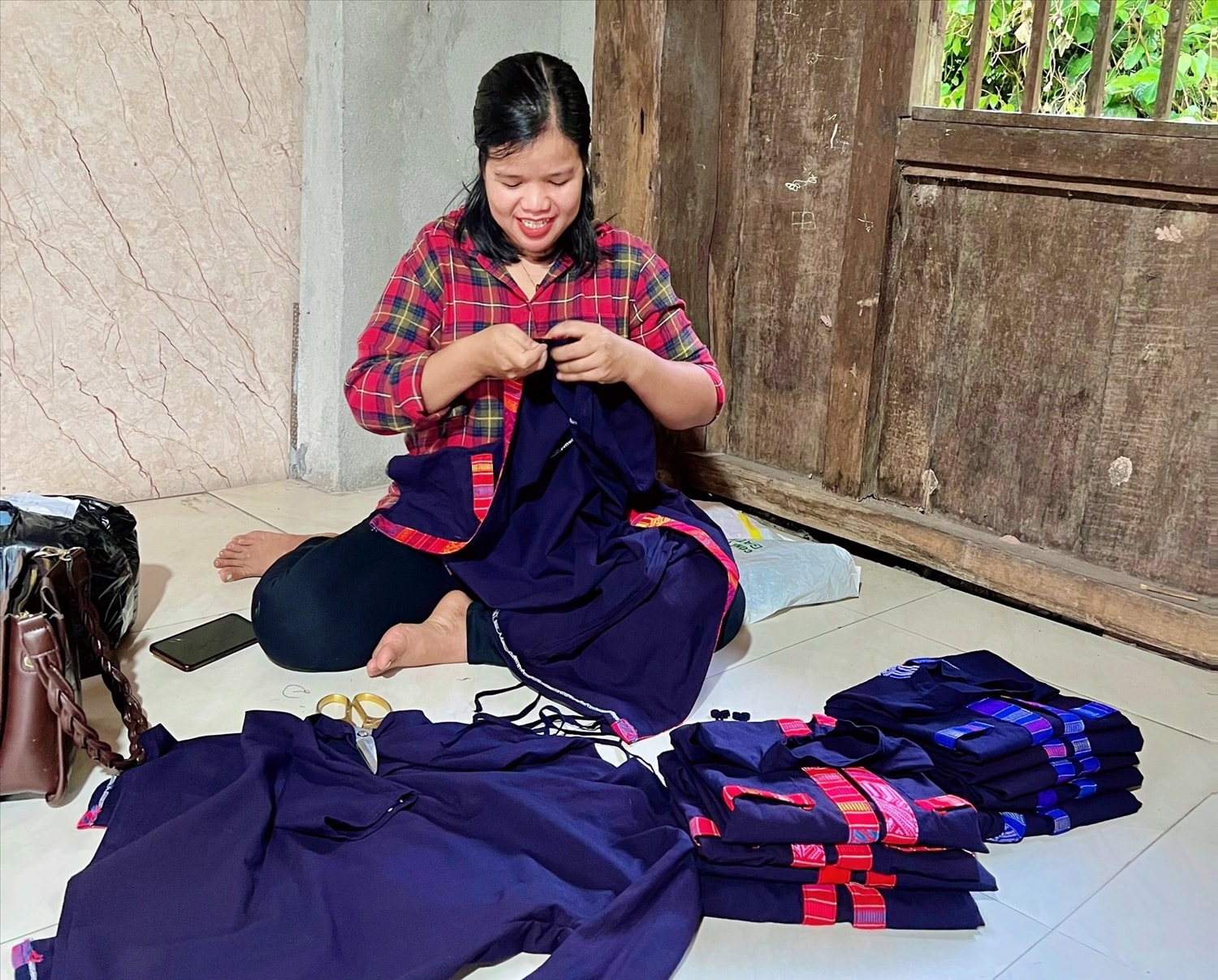 Phụ nữ dân tộc Bru - Vân Kiều  gia công lại những bộ trang phục thổ cẩm trước khi đưa đến tay khách hàng - Ảnh: T.L