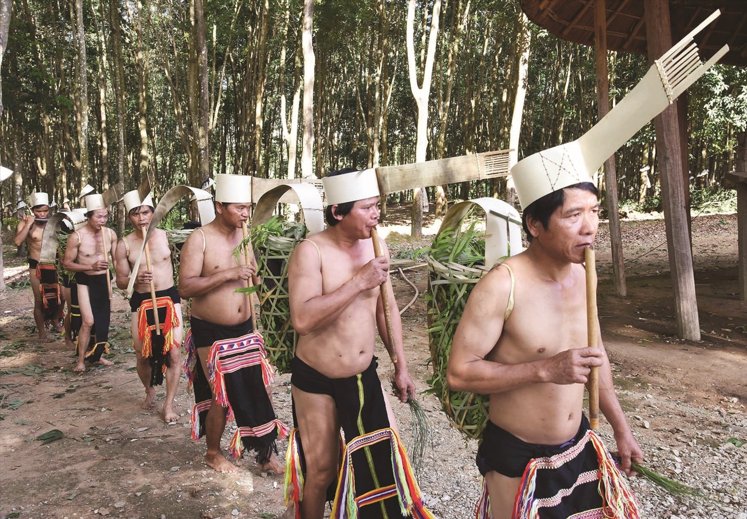 Trong Lễ hội ăn than, những người ăn than đội chiếc mũ làm bằng lá cây vừa gùi than về làng, vừa thổi đinh tút Trong Lễ hội ăn than, những người ăn than đội chiếc mũ làm bằng lá cây vừa gùi than về làng, vừa thổi đinh tút