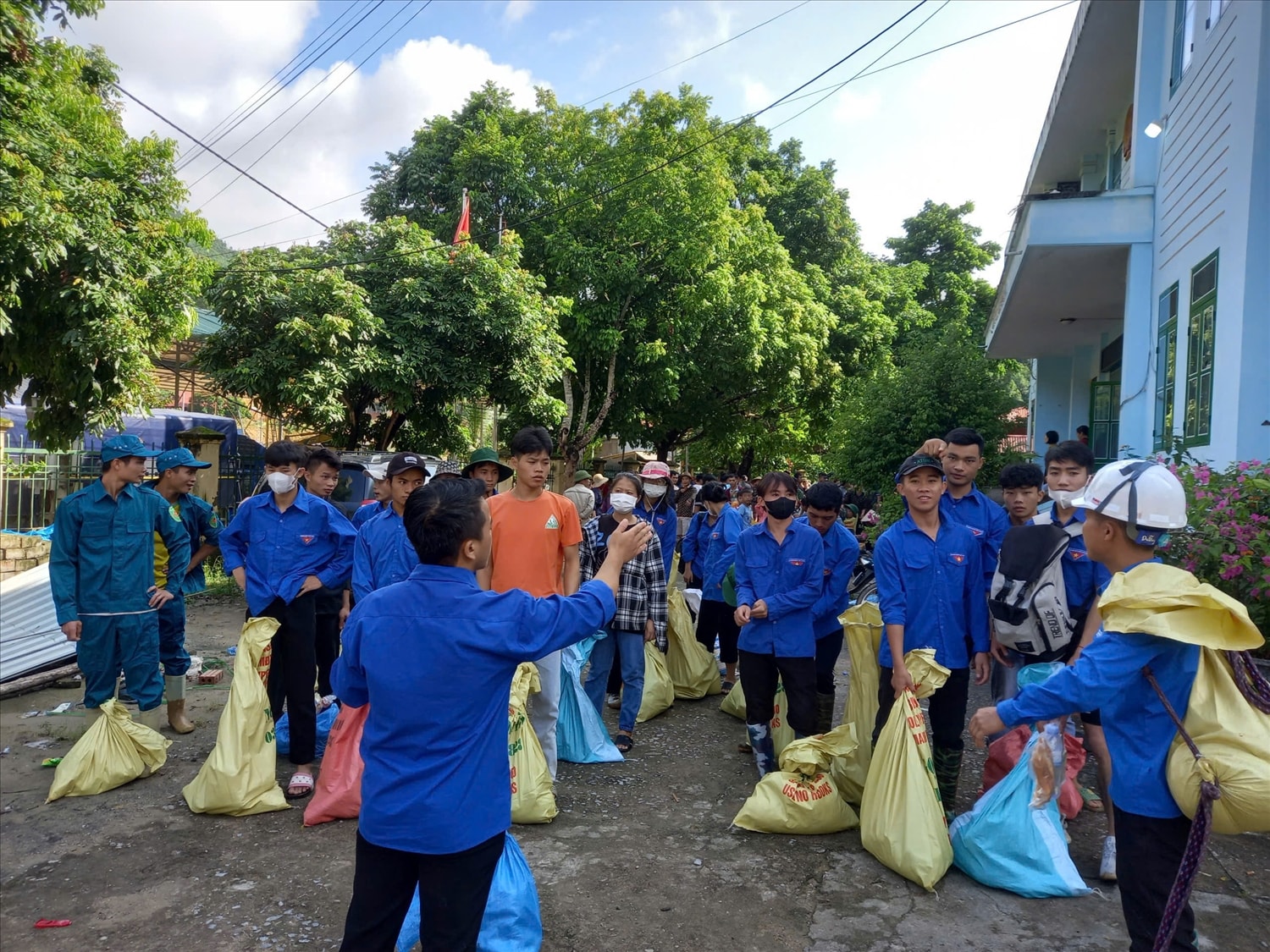 Đoàn tình nguyện tập chung nhận nhu yếu phẩm được đựng trong các bao tải để dễ dàng vận chuyển