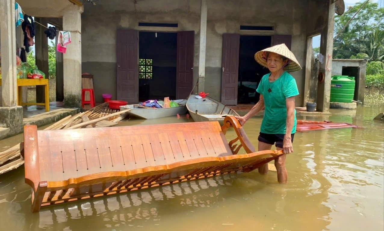 Bà Nguyễn Thị Hợp (71 tuổi, ở khu phố Ngọc Bồ) buồn rầu nhìn vật dụng trong nhà bị ngập lụt sau lũ Bà Nguyễn Thị Hợp (71 tuổi, ở khu phố Ngọc Bồ) buồn rầu nhìn vật dụng trong nhà bị ngập lụt sau lũ