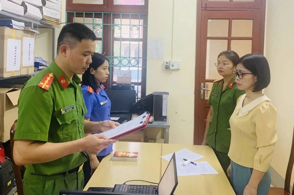 Cảnh sát tống đạt quyết định khởi tố vụ án, khởi tố bị can đối với Đồng Thị Ngọc. (Ảnh: Viện Kiểm sát nhân dân tỉnh Hà Giang)