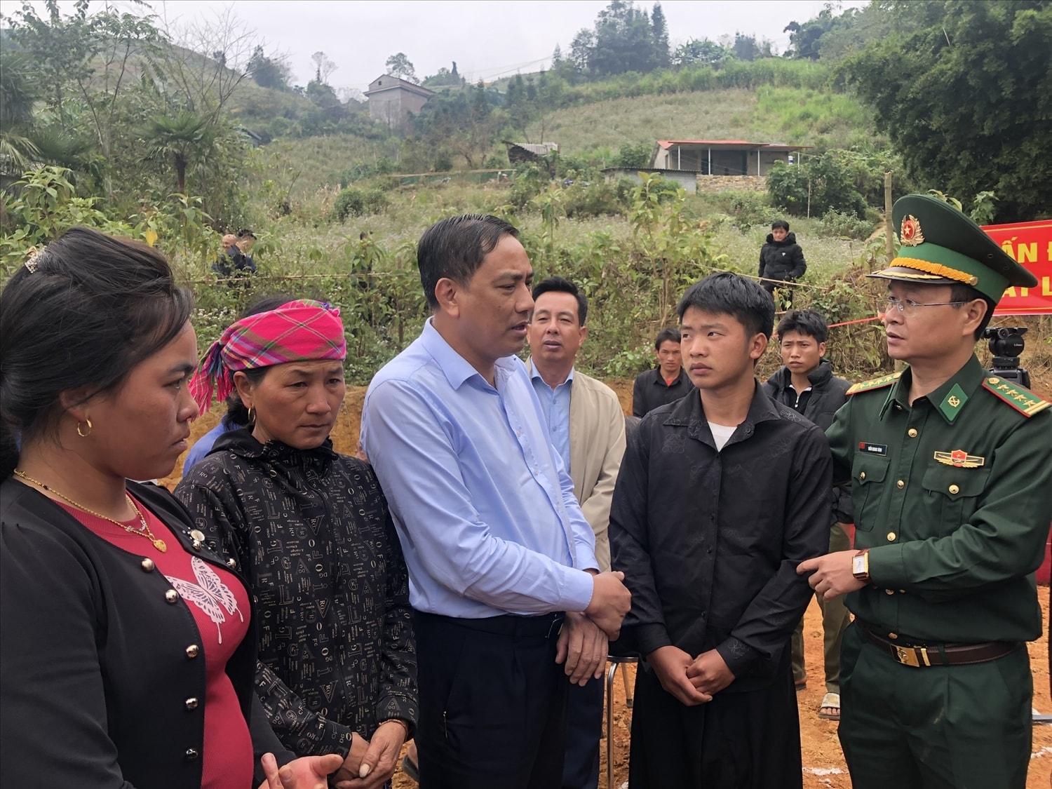 Phó Bí thư Tỉnh ủy Lào Cai Hoàng Giang (thứ 3 từ trái qua), Đại Tá Trần Quang Tùng động viên, thăm hỏi em De (thứ 2 từ phải qua) và các hộ dân được hỗ trợ xây dựng nhà v