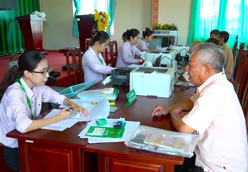 Người dân tiếp cận nguồn vốn vay tại một điểm giao dịch từ cán bộ Phòng Giao dịch Ngân hàng CSXH huyện Tân Phú  