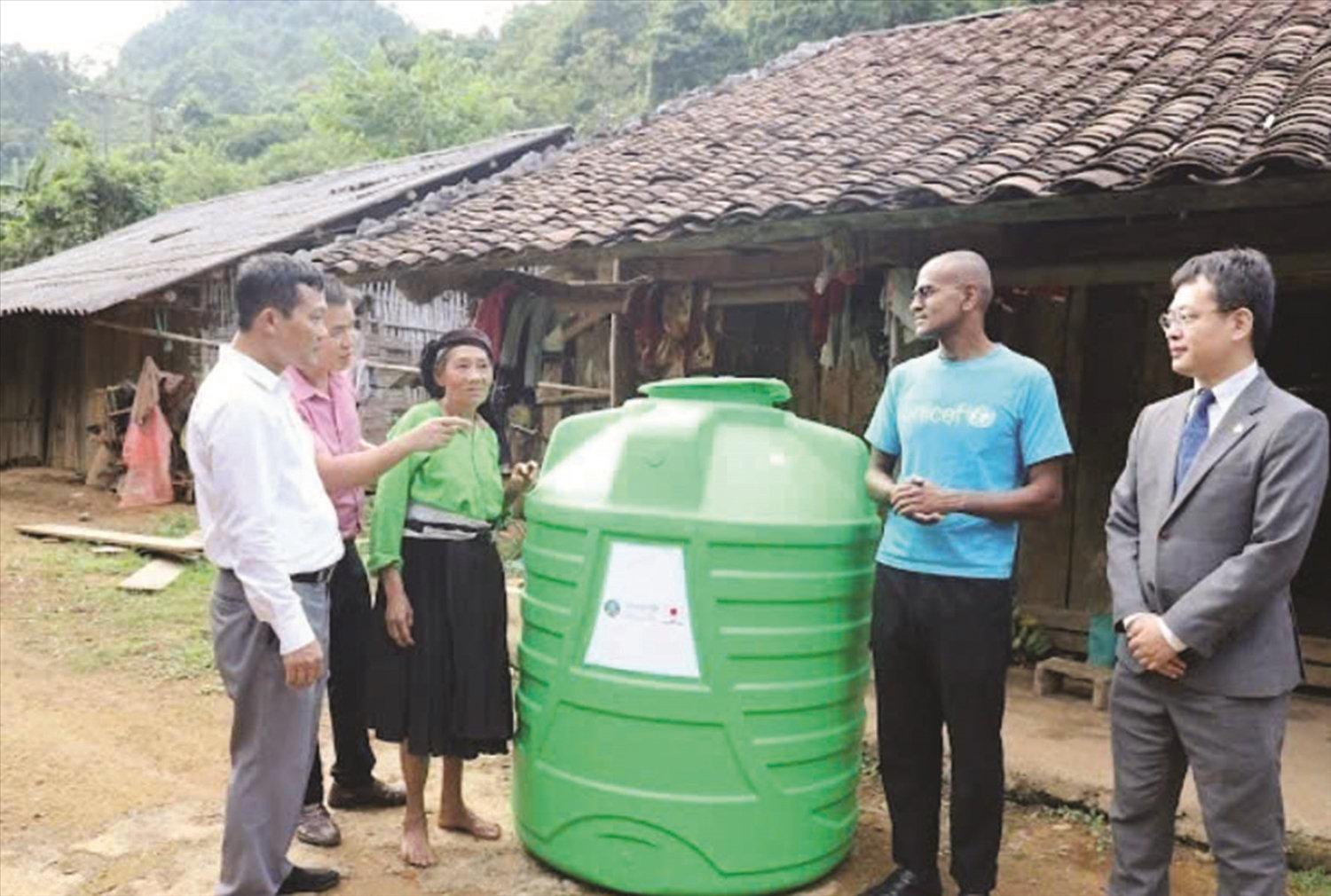 Đại diện UNICEF và đại diện chính quyền địa phương trao bồn chứa nước cho hộ DTTS. Ảnh: Chu Hiệu-TTXVN