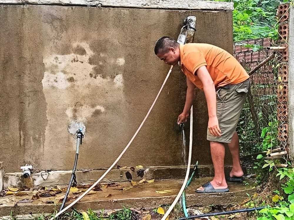Anh Sầm Văn Chung – người dân bản Đôm 2 xã Châu Phong huyện Quỳ Châu bên công trình nước sinh hoạt vừa được đầu tư theo chương trình MTQG 1719