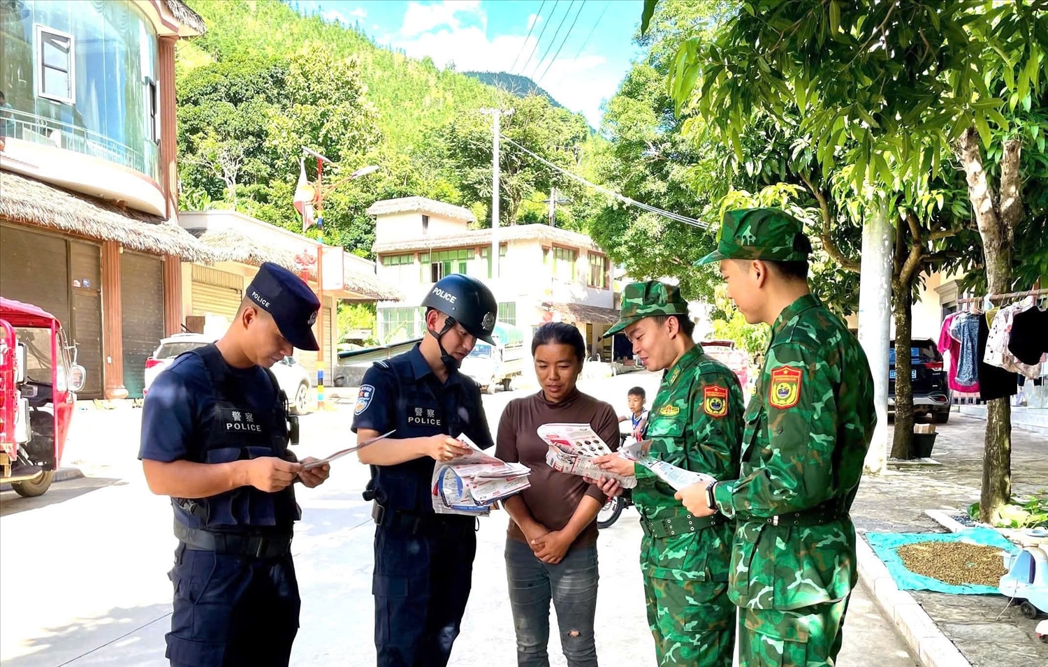 Phát tờ rơi tuyên truyền pháp luật cho cư dân biên giới bản Cửa Cải, trấn Kim Thuỷ Hà, huyện Kim Bình, châu Hồng Hà, tỉnh Vân Nam, Trung Quốc. Ảnh Đức Duẩn
