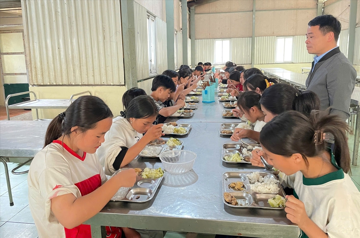 Bữa ăn trưa  của học sinh Trường PTDTBT-THCS Mường Lý (Mường Lát, Thanh Hóa) được thầy giáo giám sát chặt chẽ.