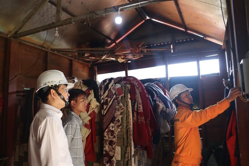 Cán bộ điện lực lắp thiết bị chiếu sáng cho các hộ gia đình Bru Vân Kiều ở xã Tân Trạch