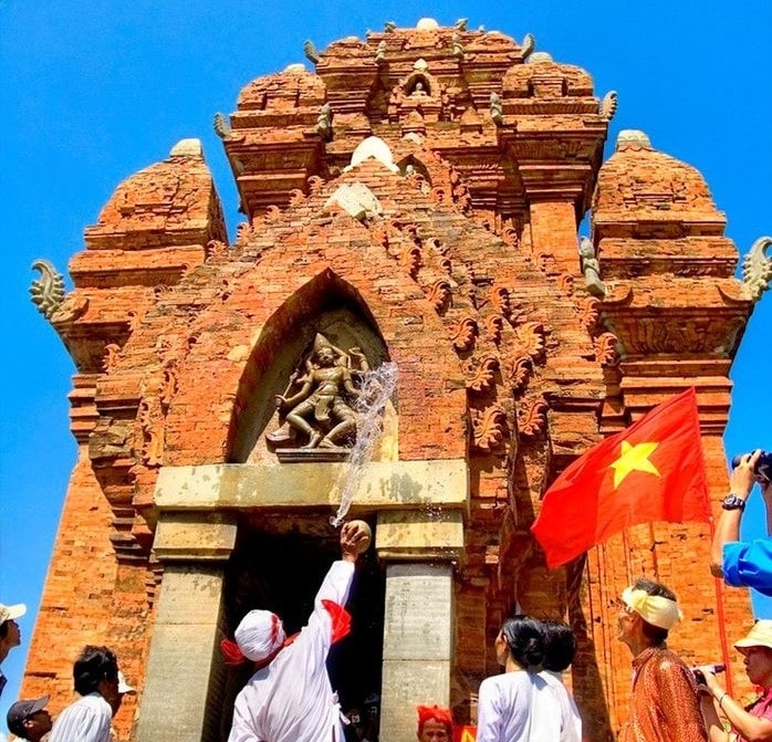 Nghi thức té nước thần Shiva trước cửa tháp, các tín đồ sẽ hứng những giọt nước thiêng thoa lên cơ thể để cầu bình anh, may mắn.